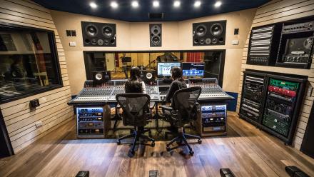 Two people working at a mixing board in a studio